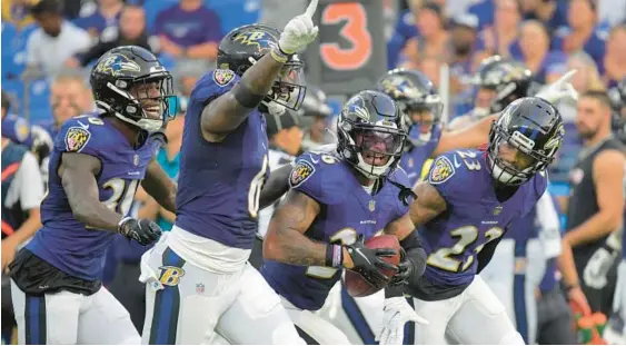  ?? KARL MERTON FERRON/BALTIMORE SUN ?? From left, Ravens cornerback Chris Westry, linebacker Patrick Queen (6) and cornerback Anthony Averett (23) celebrate a fumble recovery by safety Geno Stone (holding ball) against the Saints during the first quarter of the preseason opener Saturday night.