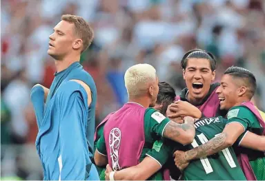  ??  ?? Mexico players celebrate as Germany goalkeeper Manuel Neuer, left, walks past Saturday in Moscow, Russia. EDUARDO VERDUGO/AP