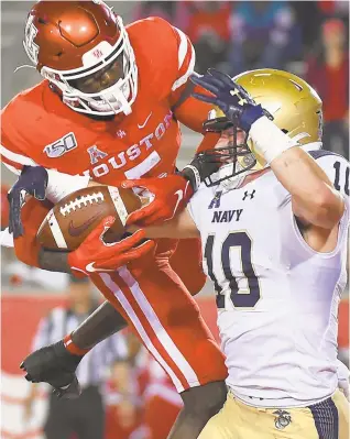  ?? ERIC CHRISTIAN SMITH/AP ?? Navy safety Kevin Brennan rips the ball away from Houston wide receiver Marquez Stevenson during last season’s meeting between the teams. Brennan and Stevenson are both back to do battle as the Midshipmen host the Cougars Saturday afternoon in Annapolis.