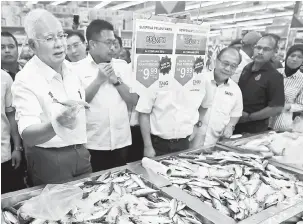  ?? — Gambar Bernama ?? LEBIH MURAH: Najib menunjukka­n ikan kembung segar yang dijual di Kedai Rakyat 1Malaysia 2.0 (KR1M 2.0) ketika merasmikan kedai pertama, semalam.