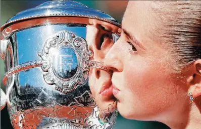  ?? GONZALO FUENTES / REUTERS ?? Latvia’s Jelena Ostapenko kisses the trophy after winning Saturday’s final of the French Open against Romania’s Simona Halep in Paris. The unseeded 20-year-old beat the world No 4 by scores of 4-6, 6-4, 6-3.