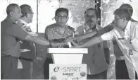  ?? ARYA DHITYA/JAWA POS ?? RESMIKAN LAYANAN: Kapolda Jawa Timur Irjen Pol Machfud Arifin (tengah) saat meresmikan layanan E-Smart Samsat kemarin.