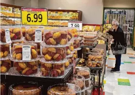  ?? Justin Sullivan/Getty Images ?? A customer shops for food at a grocery store in San Rafael. Economic growth in the U.S. for last quarter was revised up slightly to a healthy 3.4% annual rate.