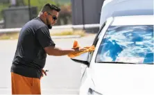  ?? Robin Jerstad / Hearst Newspapers ?? Lyft driver Eliseo Sandoval cleans his car while waiting for a passenger at San Antonio Internatio­nal Airport on Thursday.