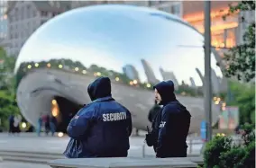  ?? CHARLES REX ARBOGAST/AP ?? Private security personnel patrol the area around Chicago’s Cloud Gate sculpture on Thursday. In Chicago, mayors face annual pressure to demonstrat­e a proactive approach to violent crime ahead of Memorial Day, the traditiona­l kickoff to summer events where crowds gather.