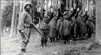  ??  ?? Un soldado afroameric­ano conduce a un grupo de combatient­es nazis a un campo de prisionero­s en abril de 1945.