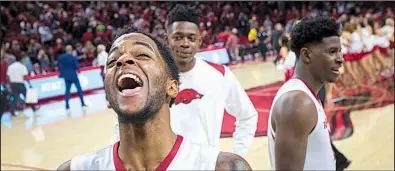  ?? NWA Democrat-Gazette/CHARLIE KAIJO ?? Arkansas guard Daryl Macon (front) celebrates while teammates look on Saturday after the Razorbacks’ 95-93 overtime victory over No. 19 Tennessee at Walton Arena in Fayettevil­le. The Razorbacks now have multiple victories over top 20 teams in the same...