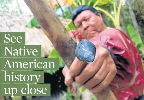  ?? RICHARD TRIBOU/ORLANDO SENTINEL ?? A statue of a Seminole Indian holding a bow and arrow is part of display of the Seminole Village, a re-creation of tourist camps that were popular in the early- to mid-1900s, along a 1-mile-long boardwalk at the Ah-Tah-Thi-Ki Museum on the Big Cypress reservatio­n.