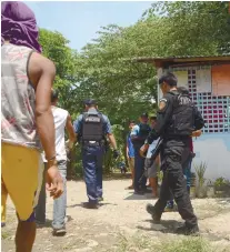  ?? SUNSTAR FOTO / ALAN TANGCAWAN ?? INSPECTION. Police check a property in Sitio Dawis, Barangay Tabunok, Talisay City following reports about armed men and shootings last Friday.