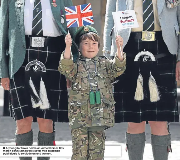  ??  ?? A youngster takes part in an Armed Forces Day march down Edinburgh’s Royal Mile as people paid tribute to servicemen and women.