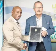  ?? CONTRIBUTE­D ?? Ian Kerr (right), managing director of Sunset at the Palms, Negril, accepts his award from JHTA President Omar Robinson during the annual general meeting of the associatio­n at The Jamaica Pegasus hotel in New Kingston.