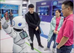  ?? PROVIDED TO CHINA DAILY ?? Visitors interact with a smart robot at a China Mobile booth during a high-tech exhibition in Guangzhou, capital of Guangdong province.