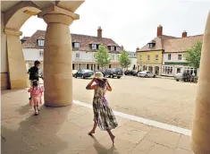  ??  ?? Playing in Poundbury: children run beneath an archway in the town’s main square