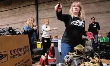  ?? John Minchillo/Associated Press ?? Valeriya Roshkovan, a volunteer for Razom for Ukraine, a New York-based nonprofit, helps package donated firefighti­ng equipment to ship to her country on Feb. 8 in Woodbridge Township, N.J.