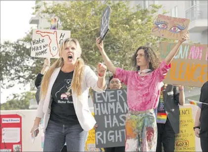  ?? Photograph­s by Carolyn Cole Los Angeles Times ?? J. MARIE BAILEY, left, a former Orange County, Fla., teacher, and Will Larkins, a high school senior, protest outside a school board meeting in Orlando. “Book banning is being weaponized to harm LGBTQ+ students and students of color,” Larkins said.