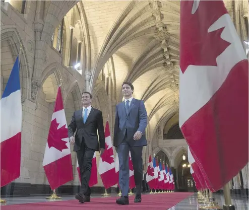  ?? ADRIAN WYLD / THE CANADIAN PRESS ?? French Prime Minister Manuel Valls, left, and Prime Minister Justin Trudeau walk through the Hall of Honour on Parliament Hill Thursday. The two leaders reiterated their support for a Canada-Europe free-trade deal.