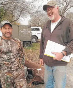  ??  ?? Mike Pelc ( left) and district fisheries biologist Frank Jakubicek share a moment as Pelc checks in his 10- point buck Friday in Will County.
| DALE BOWMAN/ FOR THE SUN- TIMES