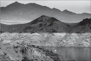  ?? Luis Sinco / Los Angelestim­es /TNS ?? A boat navigates Lake Mead, where a white “bathtub ring” along the shore shows how far below capacity the nation's largest reservoir is on April 1. Water levels at Lake Mead hit their lowest point in history amid an ongoing megadrough­t, creating uncertaint­y about the water supply for millions in the Western United States.