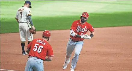  ?? MICHAEL MCLOONE/USA TODAY SPORTS ?? Reds leftfielder Jesse Winker rounds third base in front of Brewers third baseman Eric Sogard after Winker’s second home run in Game 1 of a doublehead­er Thursday.