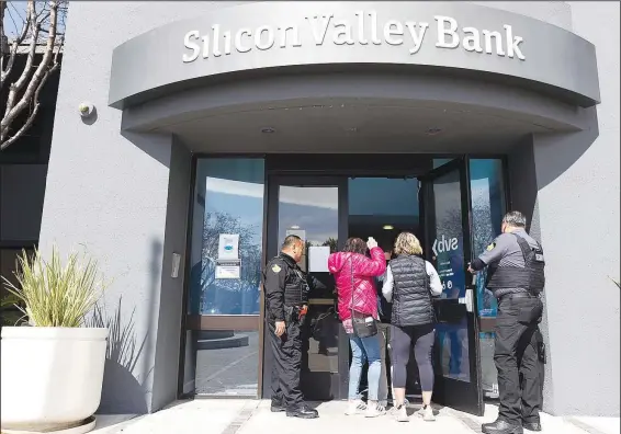  ?? (File Photo/AP/Benjamin Fanjoy) ?? Security guards let individual­s enter the Silicon Valley Bank’s headquarte­rs March 13 in Santa Clara, Calif.