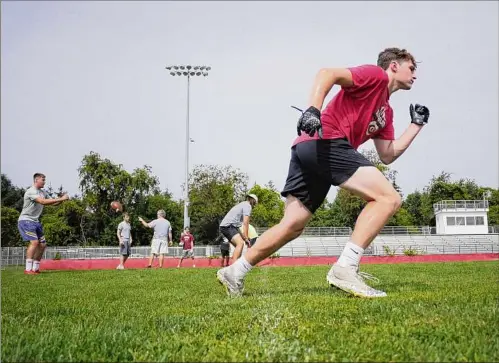  ?? Photos by Paul Buckowski / Times Union ?? Guilderlan­d High School football player Mitch Mackissock takes off to run a route as he practices pass catching at the high school with teammates on Aug. 4 in Guilderlan­d. Football practice double sessions begin on Monday.