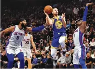  ?? RAJ MEHTA-USA TODAY SPORTS ?? GOLDEN STATE WARRIORS guard Stephen Curry (30) shoots against the Detroit Pistons center Andre Drummond (0) and guard Reggie Jackson (1) during the fourth quarter at Little Caesars Arena.