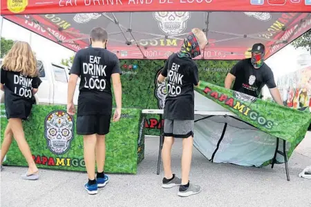  ?? AMY BETH BENNETT/SUN SENTINEL PHOTOS ?? Brian “El Jefe” Faeth, right, sets up tables July 13 at Papamigos mobile kitchen on the site of their future brick-and-mortar restaurant in Pompano Beach.