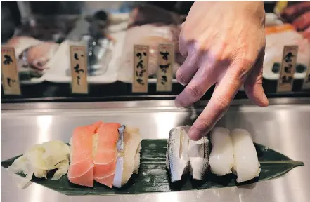  ?? — THE ASSOCIATED PRESS FILES ?? A chef serves sushi at a restaurant. New Canadians are having a growing influence on Generation Z’s overall food and beverage choices, says Kathy Perrotta at Ipsos Canada.