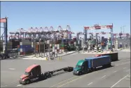  ?? Associated Press ?? Trucks travel along a loading dock at the Port of Long Beach in California.