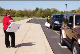  ?? BOB KEELER — MEDIANEWS GROUP ?? Dawn Kester, foreground, and Katie Boland talk to people picking up sign boards at Souderton Area High School. The signs are being decorated and returned for the Farewell Tour set for May 30.