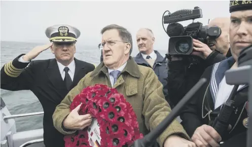 ??  ?? 0 Lord Robertson, the Islay- born former secretary general of Nato, prepares to lay a wreath at sea to honour the dead of two tragedies