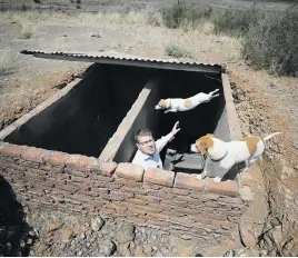  ??  ?? BATTLE READY. Suidlander movement spokespers­on Simon Roche shows a cache of supplies near Van der Kloof earlier this year.