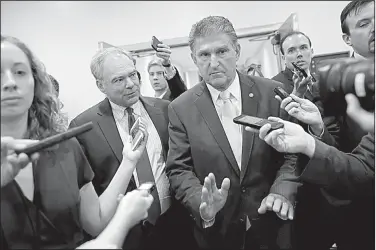  ?? AP/PABLO MARTINEZ MONSIVAIS ?? Sen. Tim Kaine, D-Va., speaks to Sen. Joe Manchin, D-W. Va., after they viewed the FBI supplement­al background report on Supreme Court nominee Brett Kavanaugh in the Capitol on Friday. Manchin is the lone Democrat to come out in support of Kavanaugh.