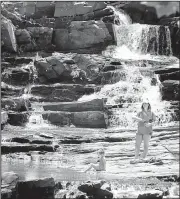  ?? AP/The Augusta Chronicle/MICHAEL HOLAHAN ?? Anna Belle Foley, 4, dips her toes in the cool water as she spends Tuesday afternoon with her baby sitter, Alexis Colston, at Rea’s Creek waterfall in Aqueduct Park in Augusta, Ga.