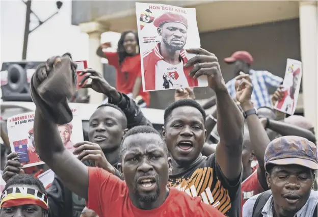  ?? PICTURE: GETTY IMAGES ?? Suporters of detained Ugandan singer-turned-politician Kyagulanyi Ssentamu react outside Kyagulanyi’s recording studios in Kampala