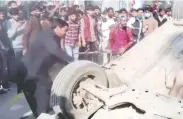  ?? REUTERS TV VIA REUTERS ?? A mob hits an overturned car with sticks after an attack on a factory in Sialkot, Pakistan, on Friday.