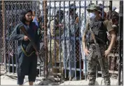  ?? MUHAMMAD SAJJAD — THE ASSOCIATED PRESS ?? A Pakistani paramilita­ry soldier, right, and a Taliban fighter stand guard on their respective sides at a border crossing point between Pakistan and Afghanista­n, in Torkham, in the Khyber district of Pakistan.