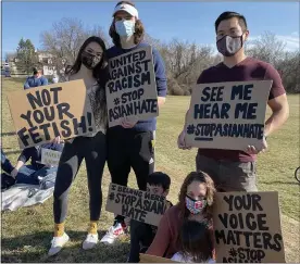  ?? PHOTO COURTESY DANIELLE KWOCK PHILLIPS ?? A group of people attending Vigil for Victims of Anti-Asian Hate Crimes pose for a photo while wearing masks and holding signs in solidarity with the Asian American Pacific Islander community.