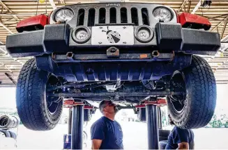  ?? JIM NOELKER / STAFF ?? Jamie’s Tire & Service manager, Rob Leach (left) and Technician James Wellman work on a Jeep Friday afternoon. The business will participat­e in Wednesday’s summer job fair at Wright State University’s Nutter Center.