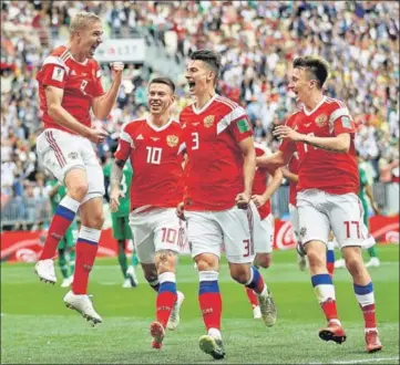  ?? REUTERS ?? ■ Russia's Yury Gazinsky (left) celebrates after scoring their first goal of the 2018 World Cup against Saudi Arabia at the Luzhniki Stadium in Moscow on Thursday. This is the fourth time a team has won by a margin of five or more goals in a World Cup...