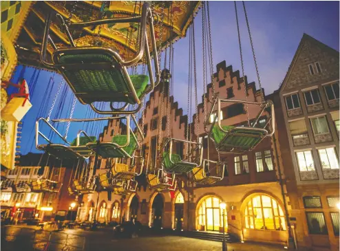  ?? MICHAEL PROBST / THE ASOCIATED PRESS ?? A flying swings ride sits empty in front of the town hall in Frankfurt, Germany, on Wednesday. It is part of an
“autumn market” slated to open Thursday but which has been delayed due to the new COVID restrictio­ns.