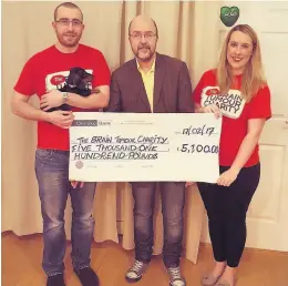  ??  ?? Donation Matthew and Hayley Smith, along with new puppy, Link, present a cheque for £5100 to Ricky Devlin from the Brain Tumour Charity