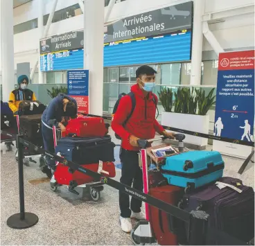  ?? FRANK GUNN / THE CANADIAN PRESS ?? Passengers from New Delhi wait in long lines at Pearson Airport in Toronto
late last week for transporta­tion to their quarantine hotels.