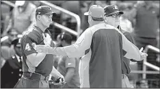  ?? AP/BILL KOSTROUN ?? The discussion between Cincinnati Reds Manager Bryan Price (center) and umpires Shane Livensparg­er (left) and Jerry Layne was just starting to heat up, but then “God Bless America” began.