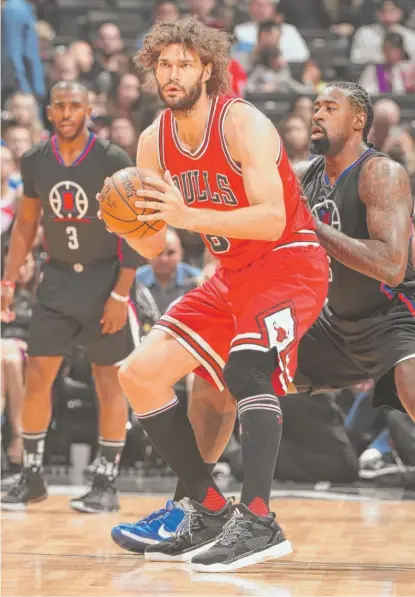  ??  ?? Bulls center Robin Lopez works against Clippers center DeAndre Jordan in the first half Saturday in Los Angeles. | GETTY IMAGES