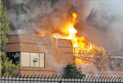  ?? Michael Quine Las Vegas Review-journal ?? An early morning fire engulfs a business complex Monday near Paradise Road and East Twain Avenue in Las Vegas.