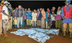  ?? AFP ?? KENYAN TRAGEDY People gather around victims’ bodies at Solai after the Patel dam burst its banks.—