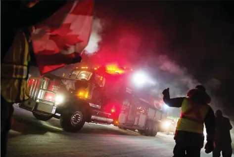  ?? BRANDON HARDER ?? Supporters of a truck convoy headed to Ottawa stand and cheer as the trucks arrive outside Moose Jaw, Sask. last week.