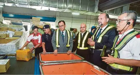  ??  ?? MENTERI Komunikasi dan Multimedia Gobind Singh Deo (dua dari kanan) mendengar taklimat mengenai operasi pengasinga­n barang dalam lawatan ke IPC Shah Alam, semalam.