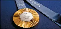  ?? Reuters -Yonhap ?? A Paris 2024 Olympic Games gold medal is seen on display at a Chaumet store in Paris, Feb. 1.